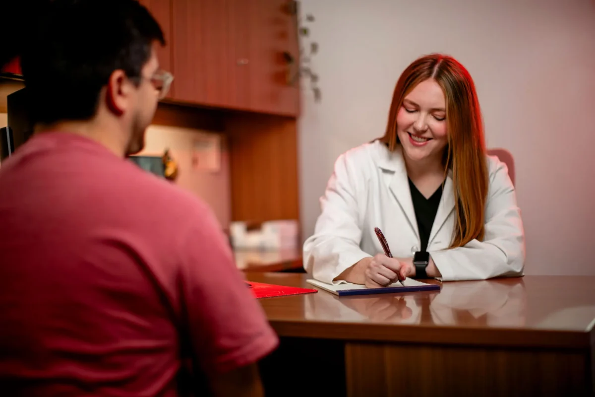 DNP student consulting with a patient and taking notes during a clinical appointment
