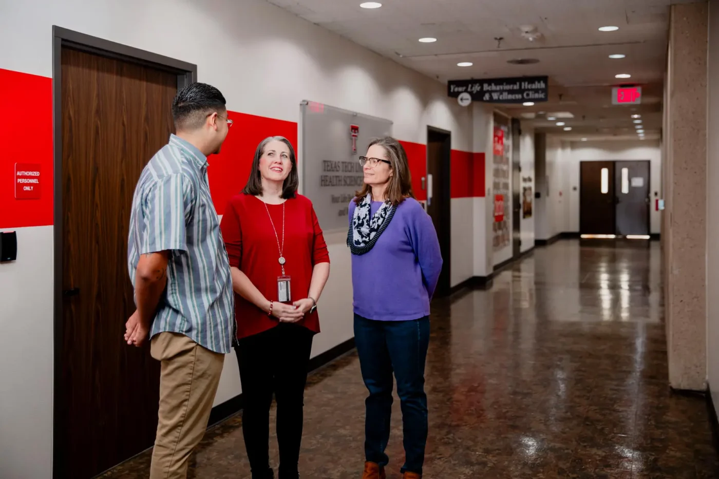 Faculty and student discussing academic programs in the Texas Tech University Health Sciences Center hallway